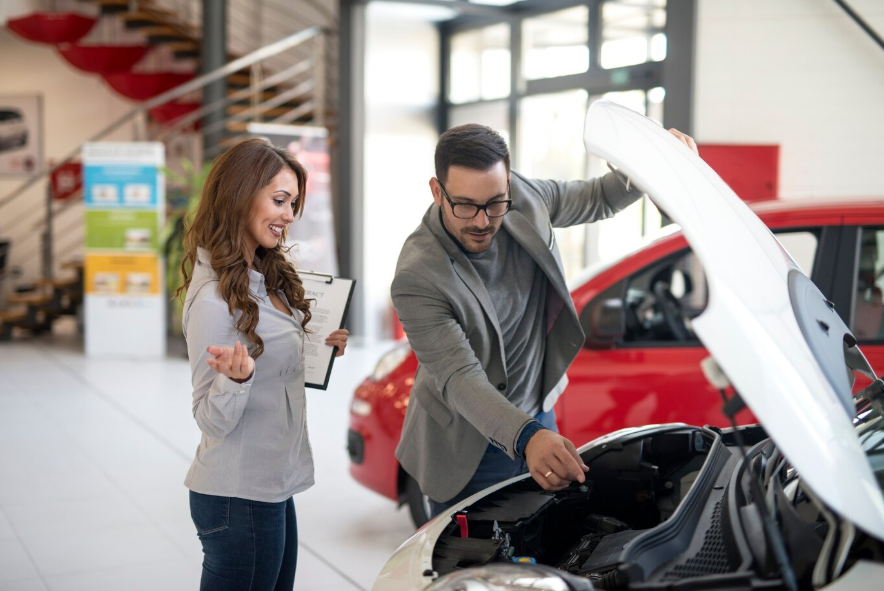 a man and woman inspecting a car